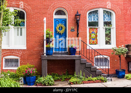 Friedrich, USA - 24. Mai 2017: Wohn Haus Eingang in Innenstadt mit Backstein-Architektur und bunten Veranda mit Blumen im Sommer Stockfoto