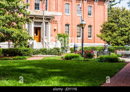 Friedrich, USA - 24. Mai 2017: Rathaus in der Innenstadt in Maryland mit Backsteinbau außen, Zeichen und Park-Platz mit Blumen und Polizist Stockfoto