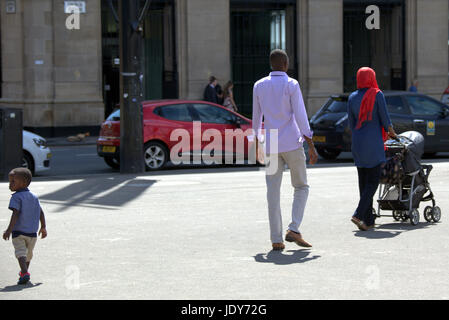 Asiatische Familie Flüchtling gekleidet Hijab Schal auf Straße in der UK alltägliche Szene kleiner Junge fast verloren Stockfoto