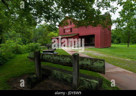 Bank und alten Schleifstein vor Bonneyville Mills Park, Bristol, Indiana. Stockfoto