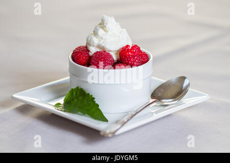 Ein Dessert frische Himbeeren und Schlagsahne im Restaurant Einstellung. Stockfoto