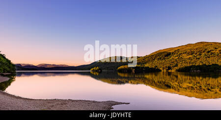 Wunderschön ruhig am Abend nach Norden suchen Coniston Water aus dem westlichen Ufer in der Nähe des Sunset mit verblüffenden Reflexionen und Farben Stockfoto