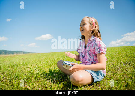 Cute Teen Mädchen spielen Tamburin und Gesang - im Freien in der Natur Stockfoto