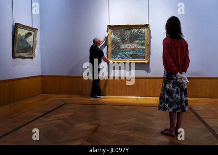 Birmingham, Vereinigtes Königreich. 22. Juni 2017. Monet Meisterwerk geht auf dem Display bei Barber Institute of Fine Arts, Birmingham Claude Monets Seerosenteich, 1899, ist in der Galerie am Barber Institute of Fine Arts, University of Birmingham hing, durch kuratorische Techniker John van Boolen und Assistant Curator Helen Cobby.  Monets Seerosen Gemälde ausgeliehen von a-Dur uns geht Kunstmuseum auf dem Display in den Galerien an der Barber Institute of Fine Arts, an der University of Birmingham, diese Woche. Bildnachweis: Edward Moss/Alamy Live-Nachrichten Stockfoto