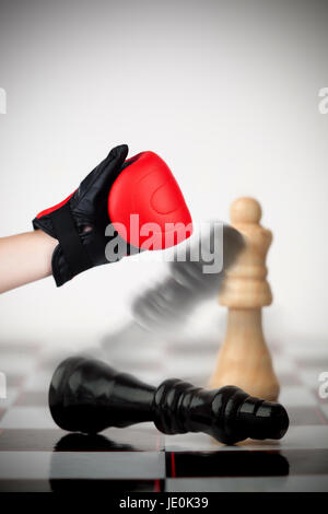 Hand der Boxer schwarz Schachfigur auf Schachbrett umzuwerfen Stockfoto