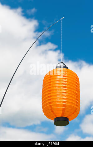 Orange Papierlaterne hängen vor einem blauen bewölkten Himmel Stockfoto