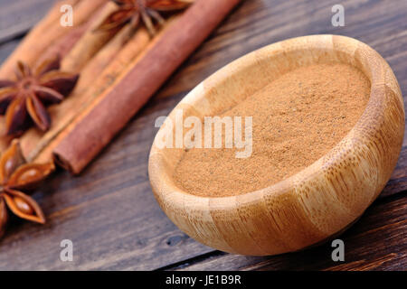 Zimtpulver in einer Schüssel mit Sternanis und Zimt klebt auf Holztisch Stockfoto