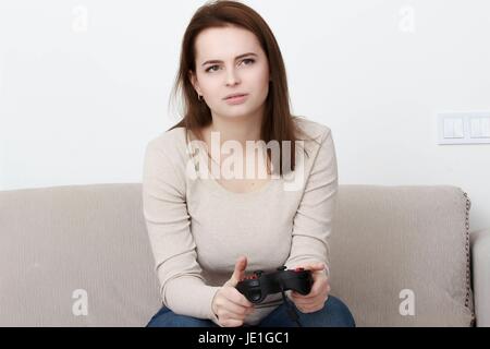 Hübsche Teenager spielen Videospiel zu Hause sitzen auf der couch Stockfoto