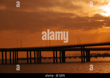 Shenzhen Bucht-Brücke bei Sonnenuntergang; Anbindung der Hongkong und Shenzhen, Provinz Guangdong, Volksrepublik China; Shekou Port im Hintergrund; Stockfoto