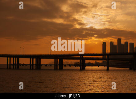 Shenzhen Bucht-Brücke bei Sonnenuntergang; Anbindung der Hongkong und Shenzhen, Provinz Guangdong, Volksrepublik China; Shekou Port im Hintergrund; Stockfoto