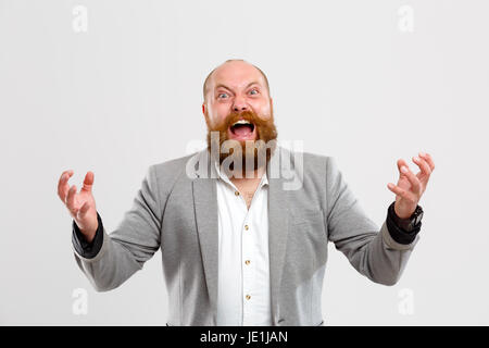 Brutaler schreienden Mann mit Ingwer Bart in graue Jacke auf leeren Hintergrund Stockfoto