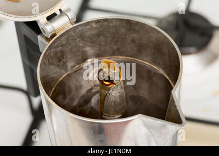 Kaffeetopf auf dem Herd mit Kaffee steigt Stockfoto