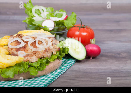 Sehr leckere hausgemachte Chicken Burger mit Pommes frites, frischem Salat, Zwiebeln, Tomaten und Gurken vorbereiten. Mit dem leeren Raum für Ihren Text. Stockfoto