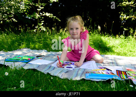 4 Jahre altes Mädchen im Freien mit Farbstifte, Greatham, Hampshire, UK. 17. Juni 2017. Stockfoto