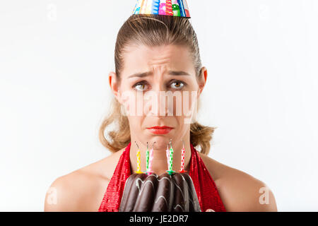 Frau feiert Geburtstag mit Kuchen Kerzen ausgelöscht werden, sie ist schlecht gelaunt Stockfoto