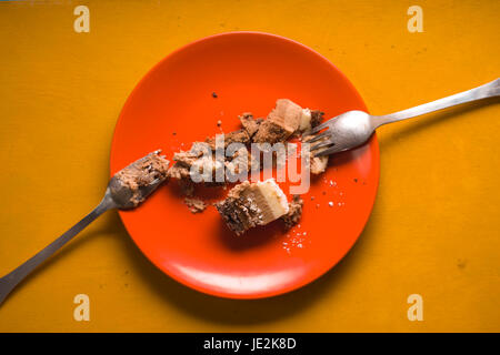 Bleibt der Kuchen in der Draufsicht orange Platte horizontal Stockfoto