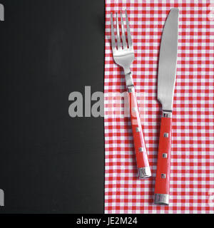 Küchenutensilien auf rot weiß karierte Tuch am schwarzen Tisch hautnah. Stockfoto