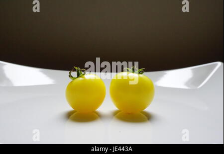 Zwei Gelbe Cherrytomaten auf einem weißen Teller Stockfoto
