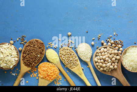 Verschiedene Arten von Getreide in hölzerne Löffel - Kichererbsen, Reis, Quinoa, Buchweizen, Linsen Stockfoto