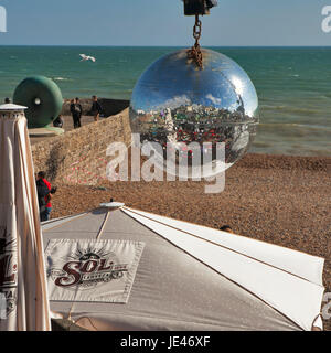 Brighton, ENGLAND - 12. Juli 2016 Brighton Beach spiegelt sich in einer Spiegelkugel hängen in einem der Cafés direkt am Strand Stockfoto