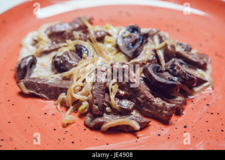 Eintopf mit Champignons und Zwiebeln in Soße. Stockfoto