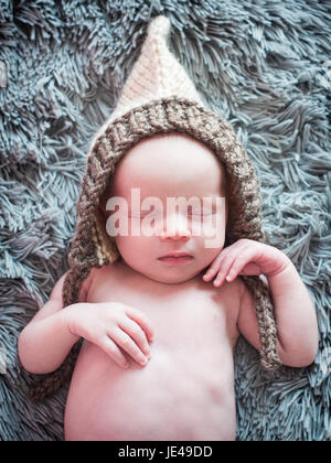 Neugeborenes Baby schläft in einer Strickmütze Stockfoto