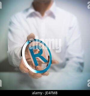 Mann mit metallischen registrierte Marke-Symbol. Konzept-Bild zur Illustration des geistigen Eigentums oder zum Schutz von Produkten oder Dienstleistungen. Stockfoto