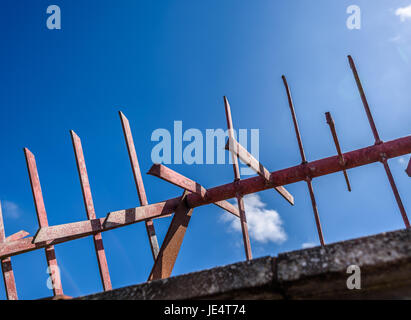 Rot Metall Spikes Sicherheitsbarriere vor blauem Himmel. Stockfoto