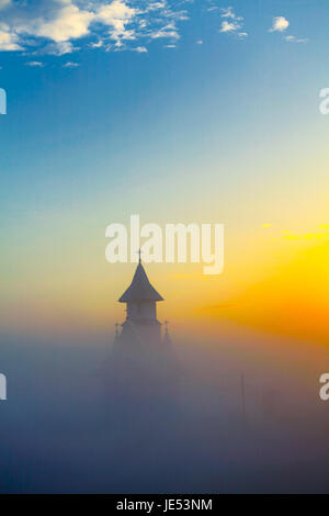 Nebel, die rund um die Kirche im Dorf Stanca, Iasi Grafschaft, Rumänien. Stockfoto