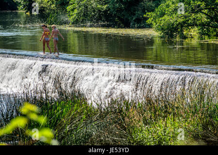 Schwimmer und Sonnenanbeter genießen das Wasser beim Warleigh Wehr am Fluss Avon in der Nähe von Bath in Somerset. Stockfoto