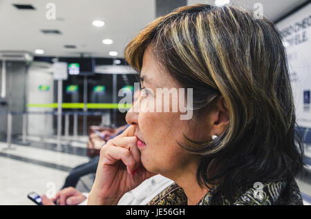 Eine Frau wartet gespannt auf die Flughafen-Abflug-Lounge hautnah. Stockfoto