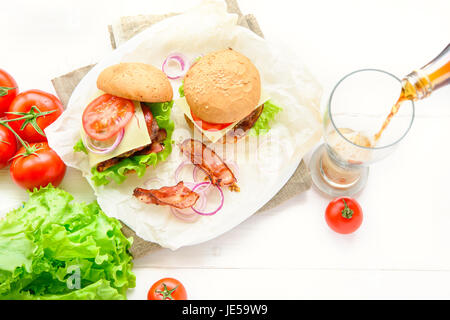 Zwei Burger serviert mit Glas Cola Soda auf weißen Tisch Stockfoto