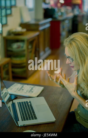 Frau mit Laptop-Computer und Gestikulieren frustriert Stockfoto