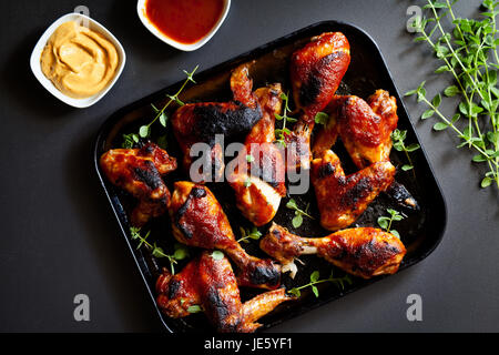 Bündel von Huhn Beine und Flügel mit Barbecue Sauce und Senf. Stockfoto