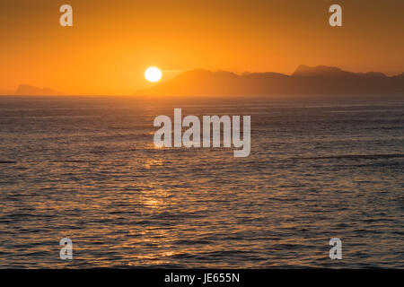 Eine helle orange Sonnenuntergang über den Bergen, Dekelders, in der Nähe von Gansbaai, Südafrika Stockfoto