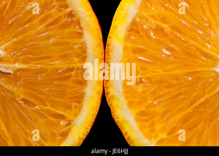 Zwei Scheiben von Orange auf einem schwarzen Hintergrund Makro Stockfoto