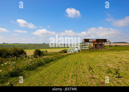 einem alten Bauernhaus auf einem Hügel mit malerischen Kulisse in der Yorkshire Wolds unter blauem Himmel im Sommer Stockfoto