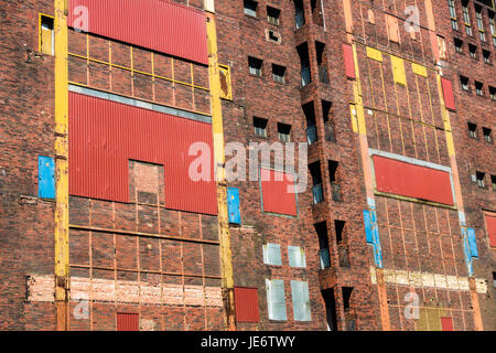 Bunte Fassade der alten, verlassenen industriellen ruinieren. abgedichtete Fenster, Türen. Stockfoto