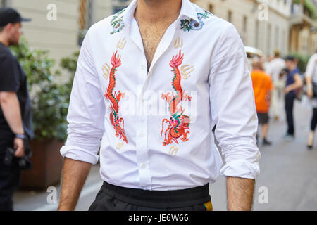 Mailand - 17.Juni: Mann mit weißem Hemd mit Orangen Drachen und Blumenschmuck vor Versace-Modenschau, Milan Fashion Week Streetstyle am Juni Stockfoto