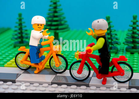 Tambow, Russische Föderation - 30. Juli 2016 Lego jungen in Helme Fahrrad im Park. Studio gedreht. Stockfoto