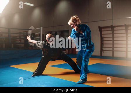 Männliche und weibliche Wushu-Kämpfer Übungen indoor, Martial-Arts. Sparring-Partner in Aktion Stockfoto