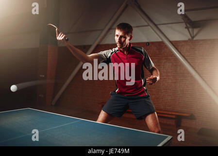 Tischtennis, männliche Spieler mit Schläger in Aktion, Ball mit Spur. Ping-Pong-Training indoor Stockfoto