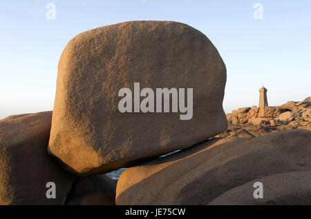 Europa, Frankreich, Bretagne, Cote de Granit rose, Ploumanach, Granitfelsen im Vordergrund, im Hintergrund einen Leuchtturm, Stockfoto