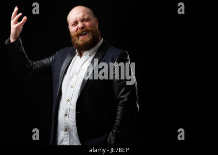 Mann mit Ingwer Bart und Schnurrbart in schwarze Jacke singt auf leeren Hintergrund Stockfoto
