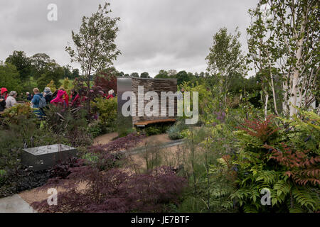 Besucher gehen ruhig, abgeschieden, Sitzgelegenheiten Bereich & Pflanzen, in einem Showgarten am ersten RHS Chatsworth Flower Show, Chatsworth House, Derbyshire, England, UK. Stockfoto