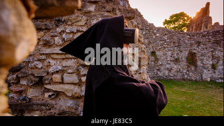 Bild genommen 19.06.17 Sperrfrist bis 00.01 23.06.17: St Augustine Abtei – Teil des Weltkulturerbe von Canterbury – wurde in der virtuellen Realität im Rahmen der Zusammenarbeit von English Heritage und der University of Kent "aufgebaut". Ab dem 24. Juni werden Besucher zu sitzen in einem neuen Pod im Visitor Centre und erleben Sie einen virtuellen Rundgang durch die reich verzierten und hell eingerichteten Gebäude, wie sie wahrscheinlich im frühen 16. Jahrhundert, kurz vor ihrer Zerstörung durch Heinrich VIII gewesen wäre.  Dies wird zum ersten Mal bei einem English Heritage Site VR verwendet worden ist. Schauspieler mit Kopfhörer Stockfoto