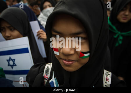 Zentral-Jakarta, Jakarta, Indonesien. 23. Juni 2017. Indonesische muslimische mit Indonesien und Palästina Flagge Aufkleber auf sie Gesicht während einer propalästinensischen Kundgebung anlässlich des internationalen Al-Quds (Jerusalem) Tages außerhalb der US-Botschaft in Jakarta, Indonesien am 23. Juni 2017. Al Quds Day (Jerusalem-Tag) ist eine jährliche Veranstaltung, die am letzten Freitag im Ramadan, die initiiert wurde von der islamischen Republik Iran im Jahr 1979 zur Unterstützung für die Palästinenser und gegen Zionismus und Israel, sowie Israels Besetzung Jerusalems und jüdische Siedlungen in Israel besetzten Gebieten. (Bild Kredit: Stockfoto