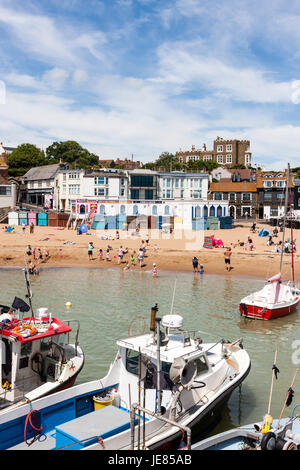 Fischerboote im Meer mit Meer und Strand vertäut mit Sonnenanbeter auf. Hintergrund, Broadstairs Stadt und die berühmten Charles Dickens home, Bleak House. Blue Sky. Stockfoto