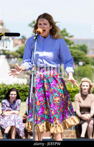 Schule Mädchen spielen der Teil der Eliza Doolittle in einer freien Produktion von 'My Fair Lady'. Vor Mikrofonstativ singen. Haar weht im Wind, Teenager Frau, im Alter von 16 und 17 Jahren. Stockfoto