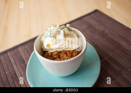 Kaffee Granit mit weißer Schokolade Schaum und wildem Fenchel, in einer blauen Tasse mit Disch, Umgebungslicht. Stockfoto